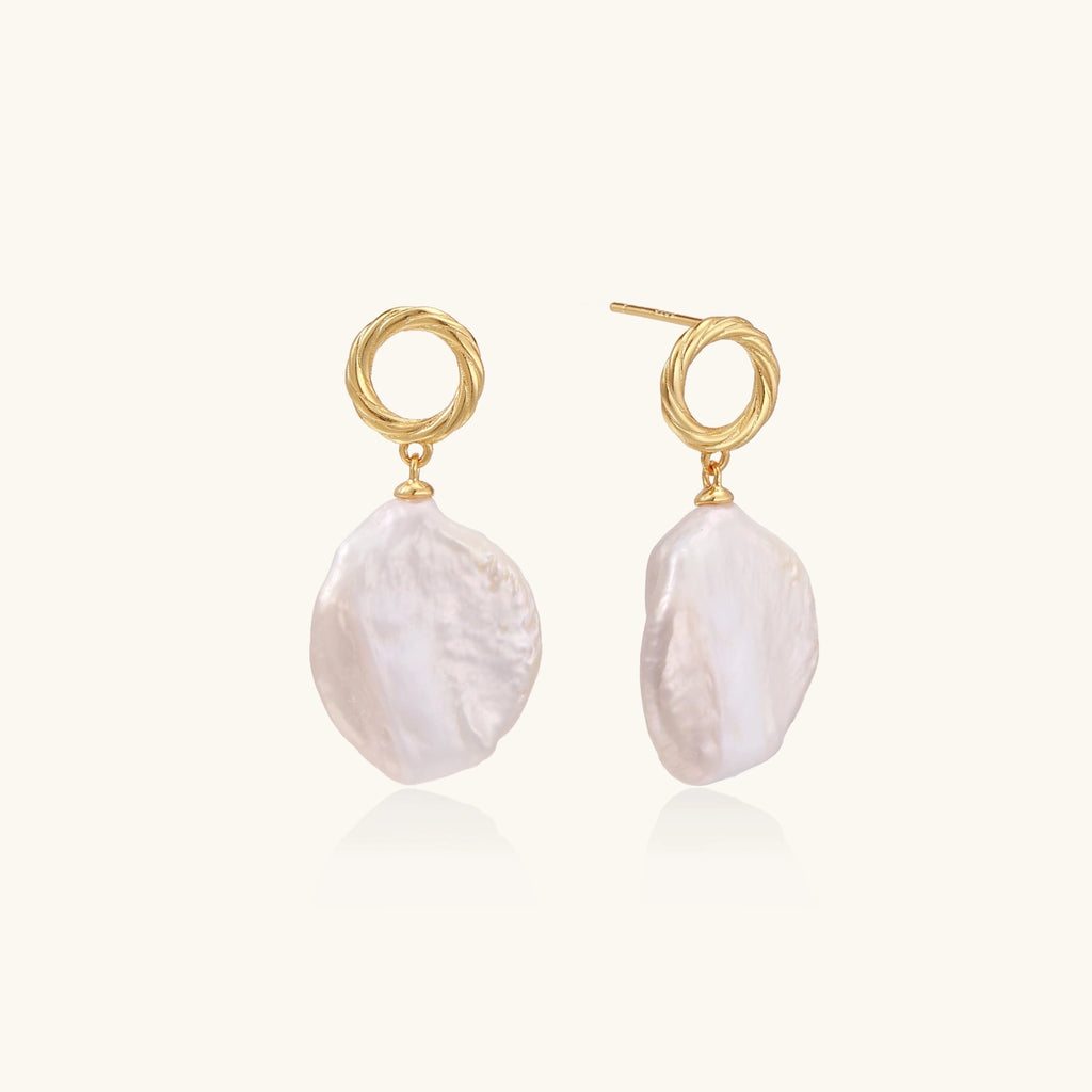 18K gold vermeil twisted circle studs with organic white baroque pearl drops on cream background
