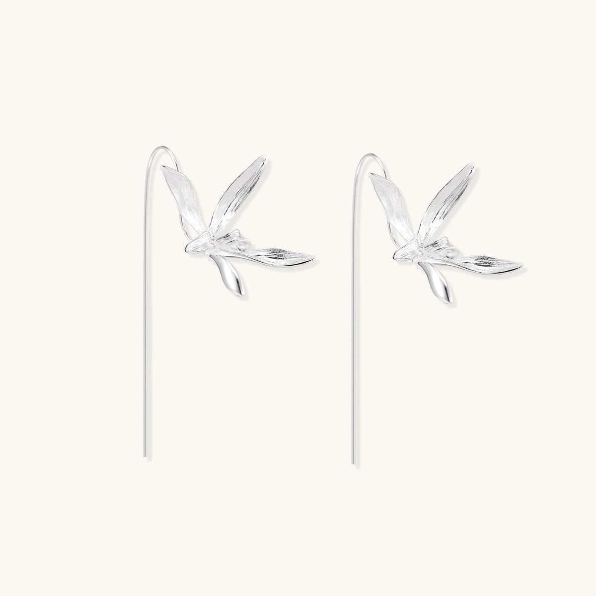 Delicate sterling silver dragonfly earrings with textured wings and curved threader hooks on white background