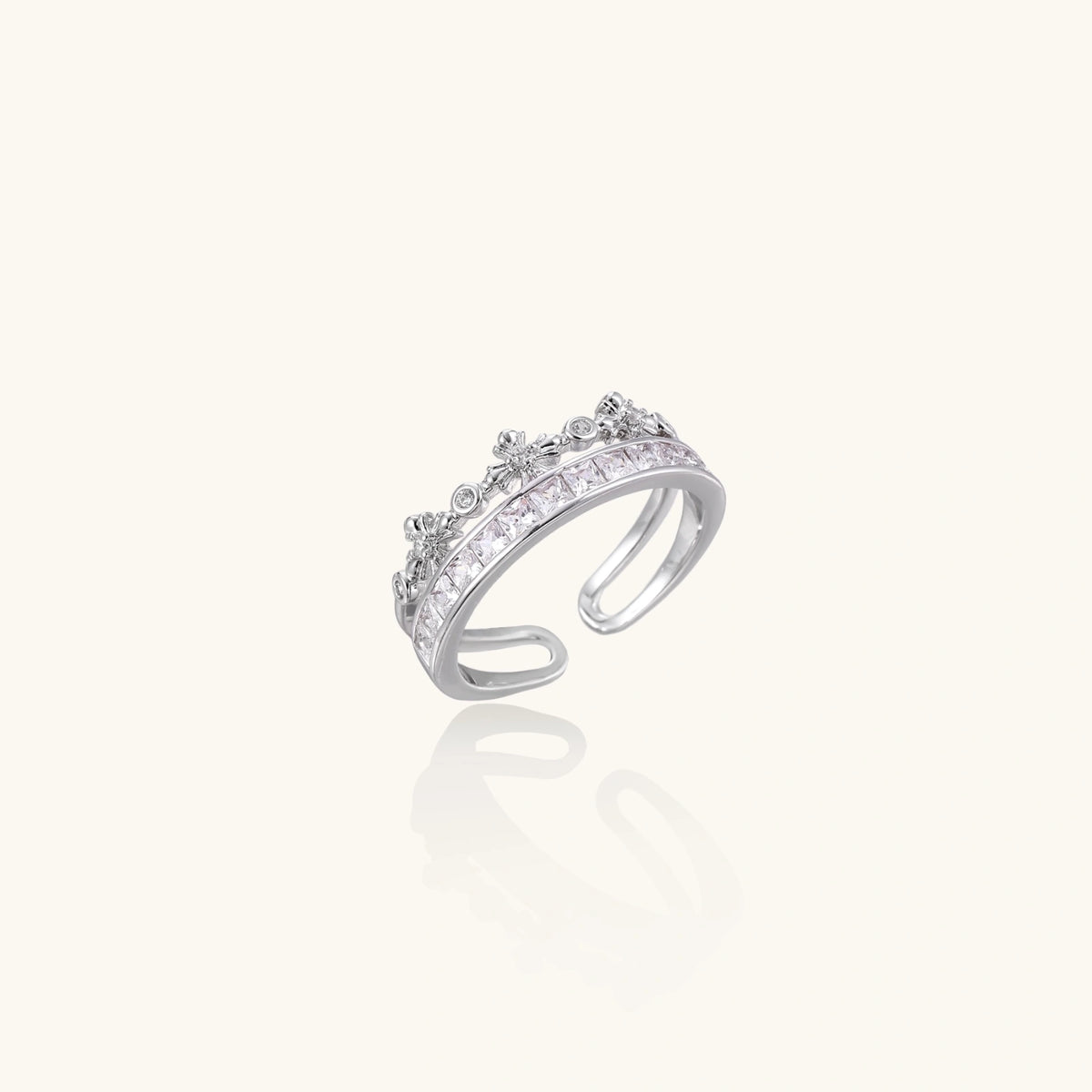 Silver-toned adjustable crown ring with channel-set square zirconia stones and delicate floral details on white background