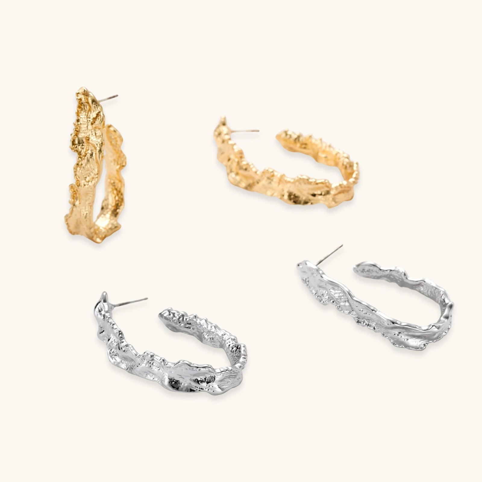 Close-up of textured gold hoop earrings with crumpled metallic surface and sterling silver posts on neutral background.