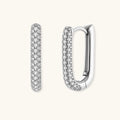 Close-up of platinum-plated sterling silver huggie hoops with pavé crystal setting on white background.