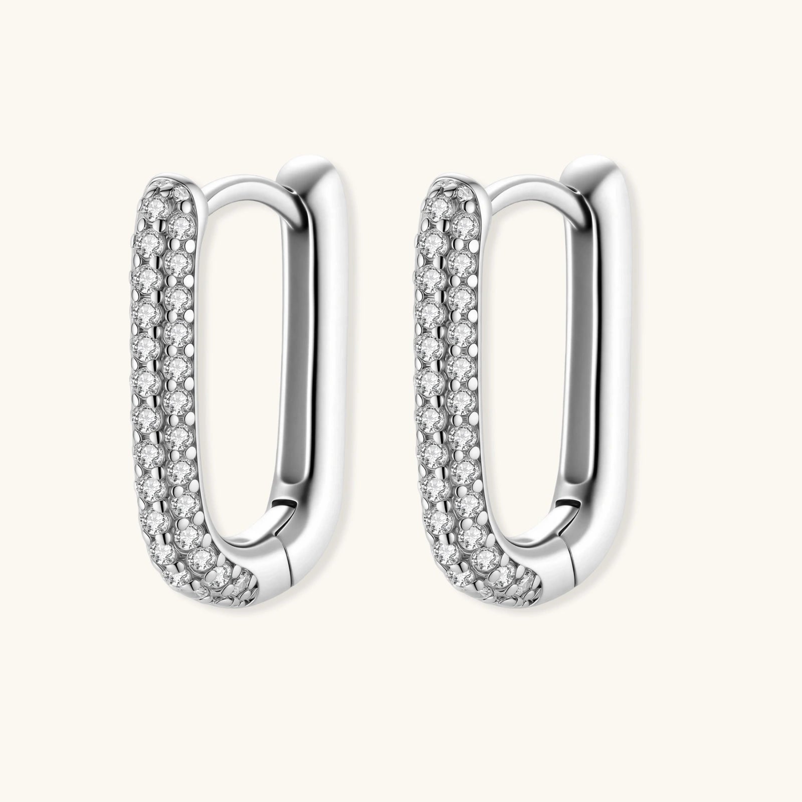 Close-up of platinum-plated sterling silver huggie hoops with pavé crystal setting on white background.