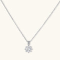 Platinum-plated sterling silver necklace with round clear crystal pendant and decorative bail on neutral background.
