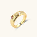 Gold-plated adjustable ring with textured band featuring champagne and purple gemstones on white background.
