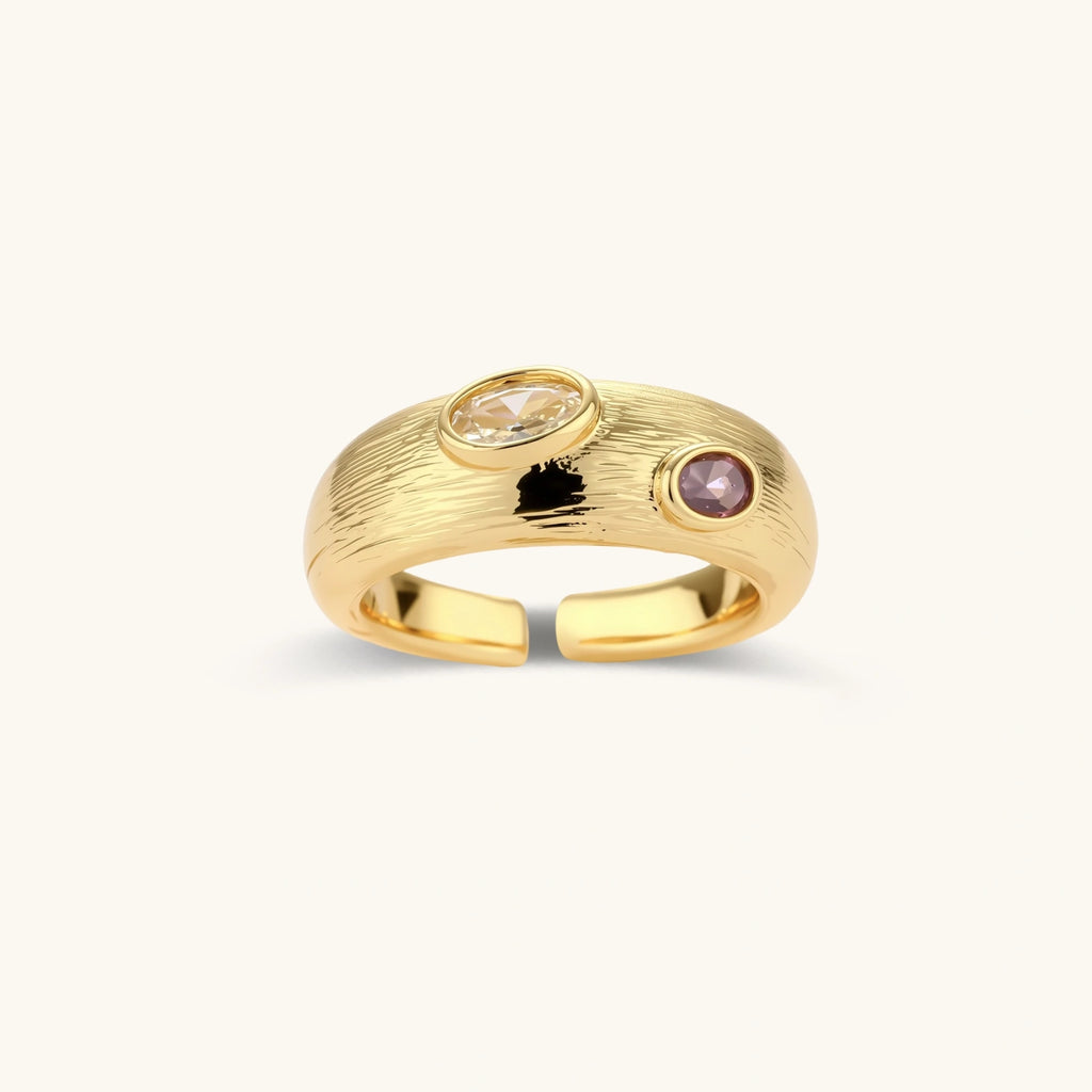 Gold-plated adjustable ring with textured band featuring champagne and purple gemstones on white background.