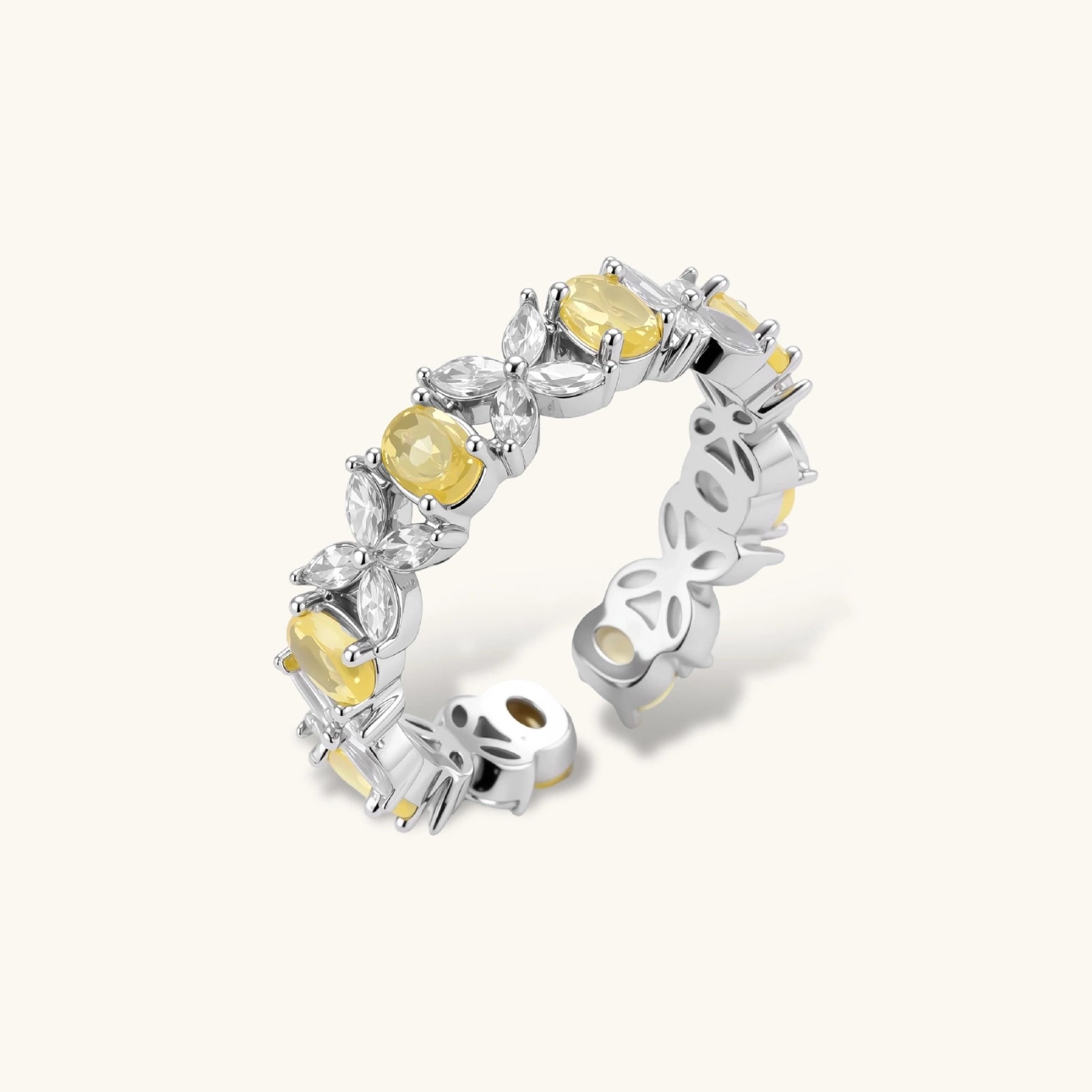 Close-up of platinum-plated copper eternity ring featuring alternating yellow and clear marquise-cut stones in elegant band setting.