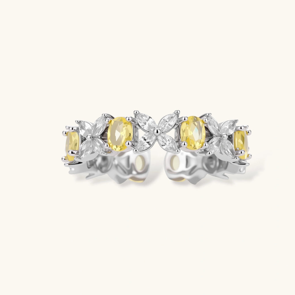 Close-up of platinum-plated copper eternity ring featuring alternating yellow and clear marquise-cut stones in elegant band setting.