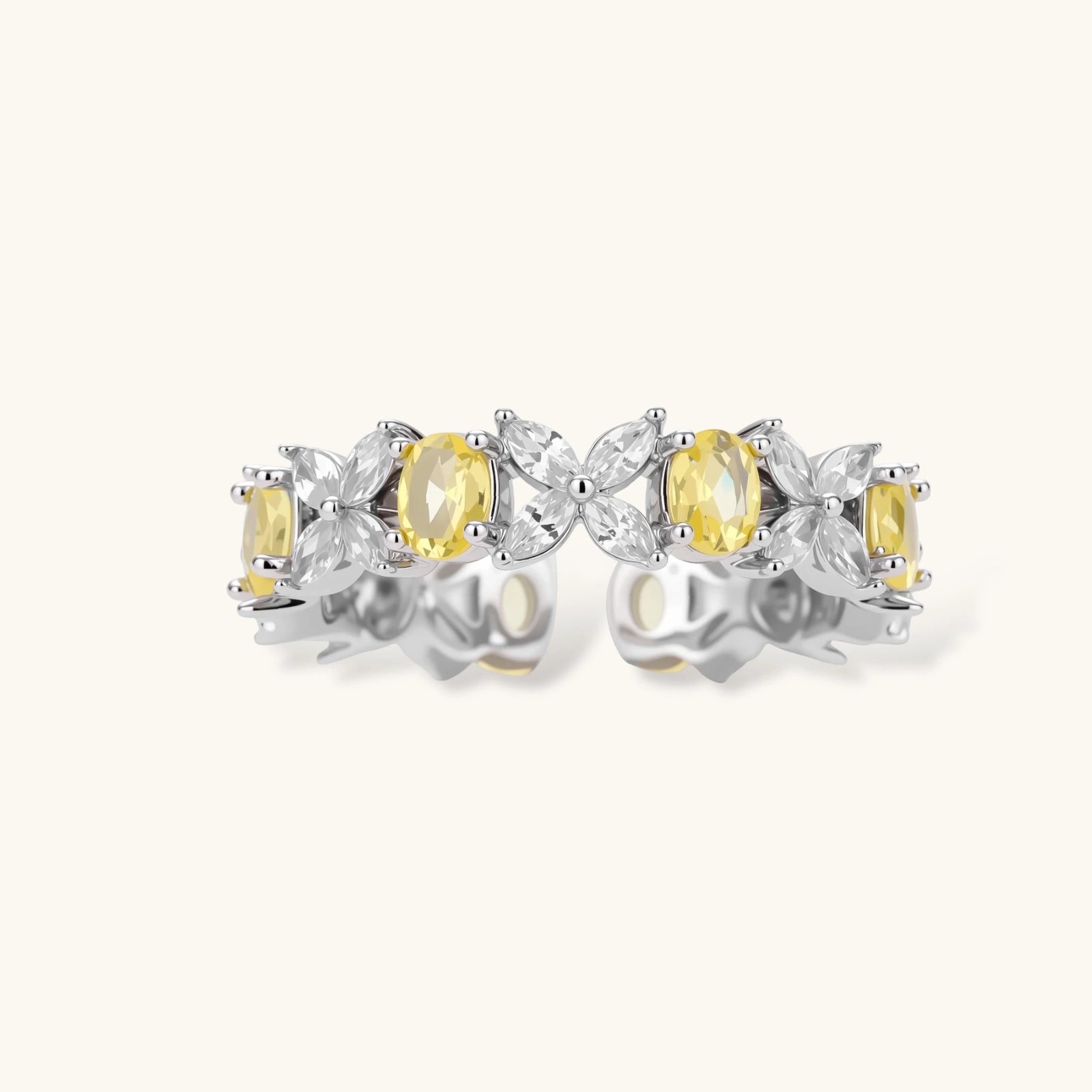 Close-up of platinum-plated copper eternity ring featuring alternating yellow and clear marquise-cut stones in elegant band setting.